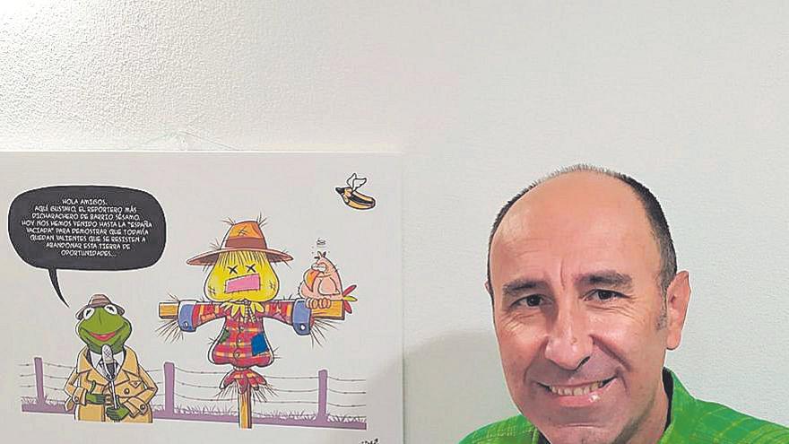 Ilustrador  Juan Andrés Cabello, ‘Elpeneque’, junto a uno de sus trabajos.