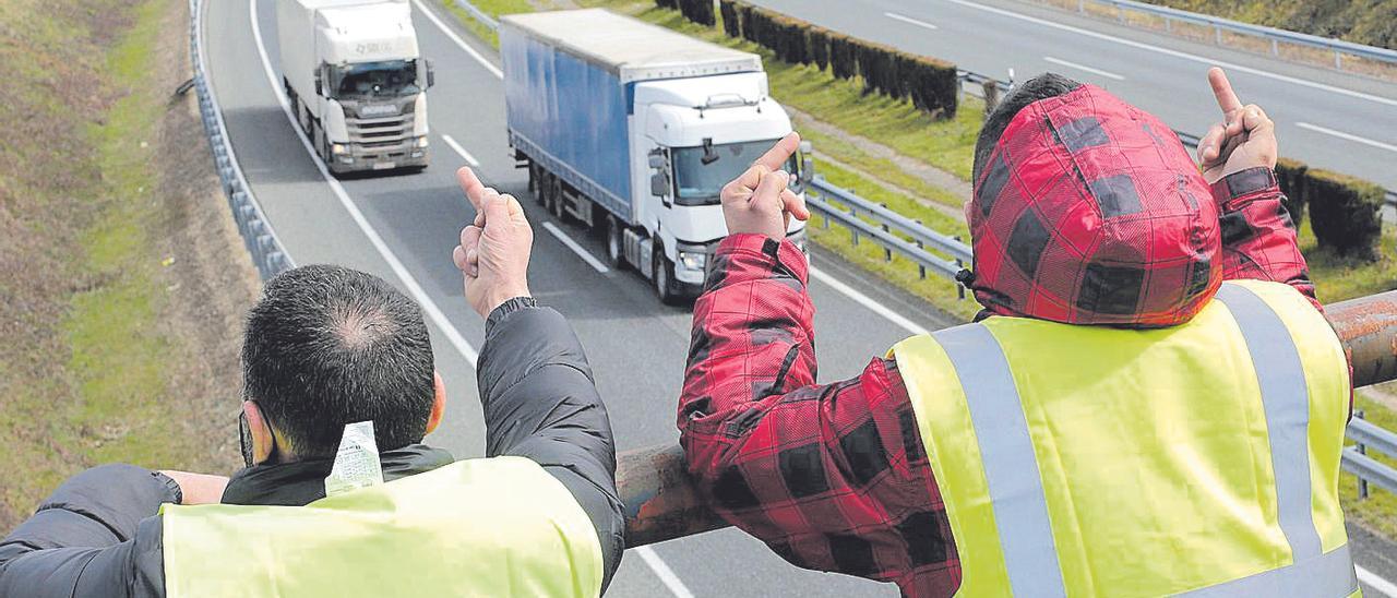 Dos miembros de un piquete insultan a los camioneros que se dirigen, este viernes, a La Coruña para entregar mercancías.