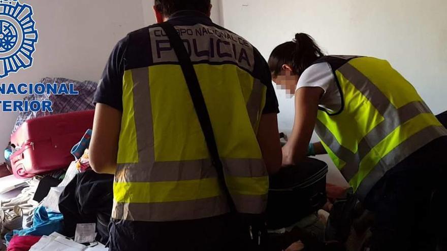 Dos policías, durante el registro de una vivienda en la operación contra la red.