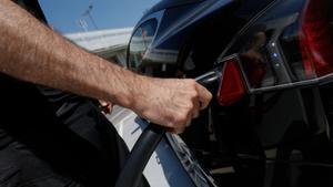 Una persona recarga un coche eléctrico en un punto de recarga.