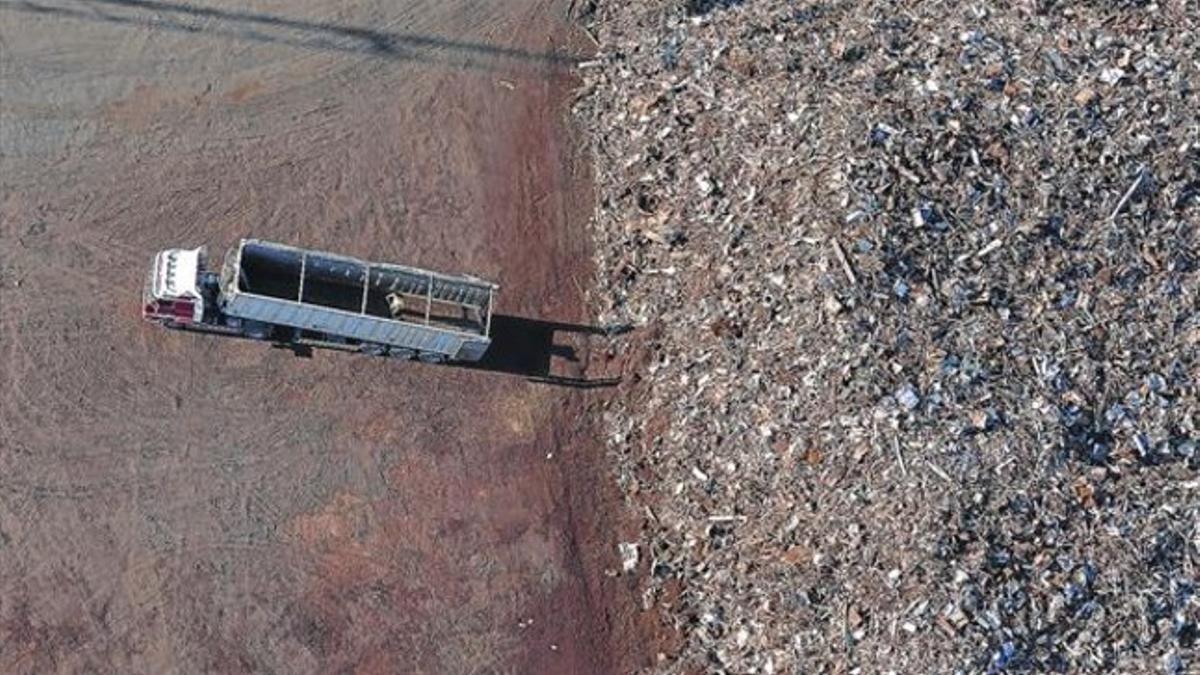 Un camión abandona un vertedero de chatarra en Catalunya tras dejar los residuos.