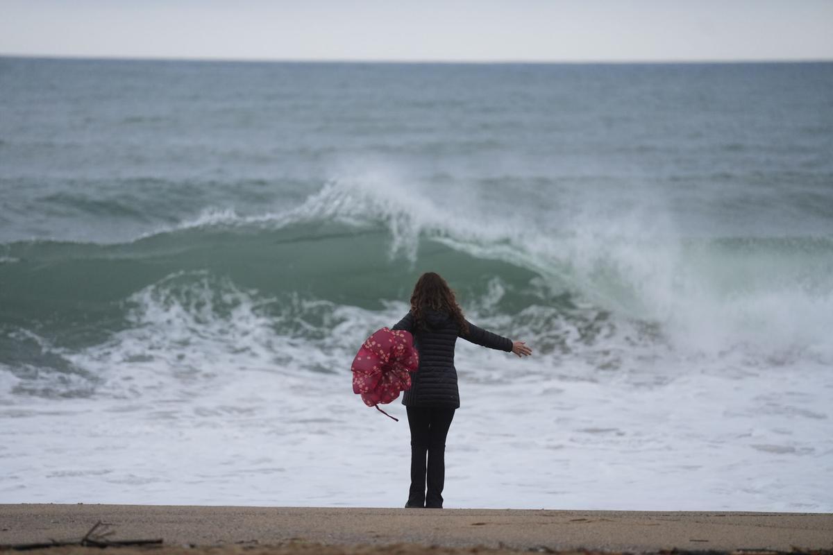 Vecinos de Barcelona pasean bajo la lluvia en la playa de la Barceloneta durante el temporal, a 19 de enero de 2026, en Barcelona, Cataluña (España).