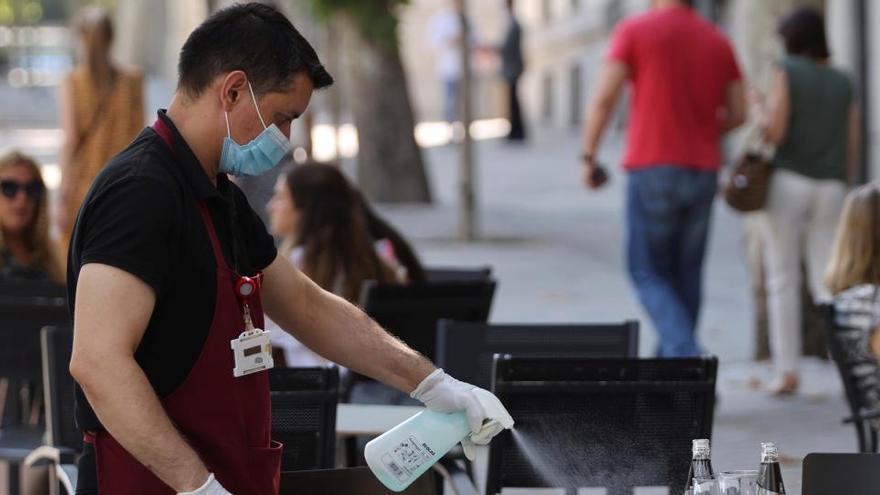 Un camarero desinfecta una mesa en Madrid.