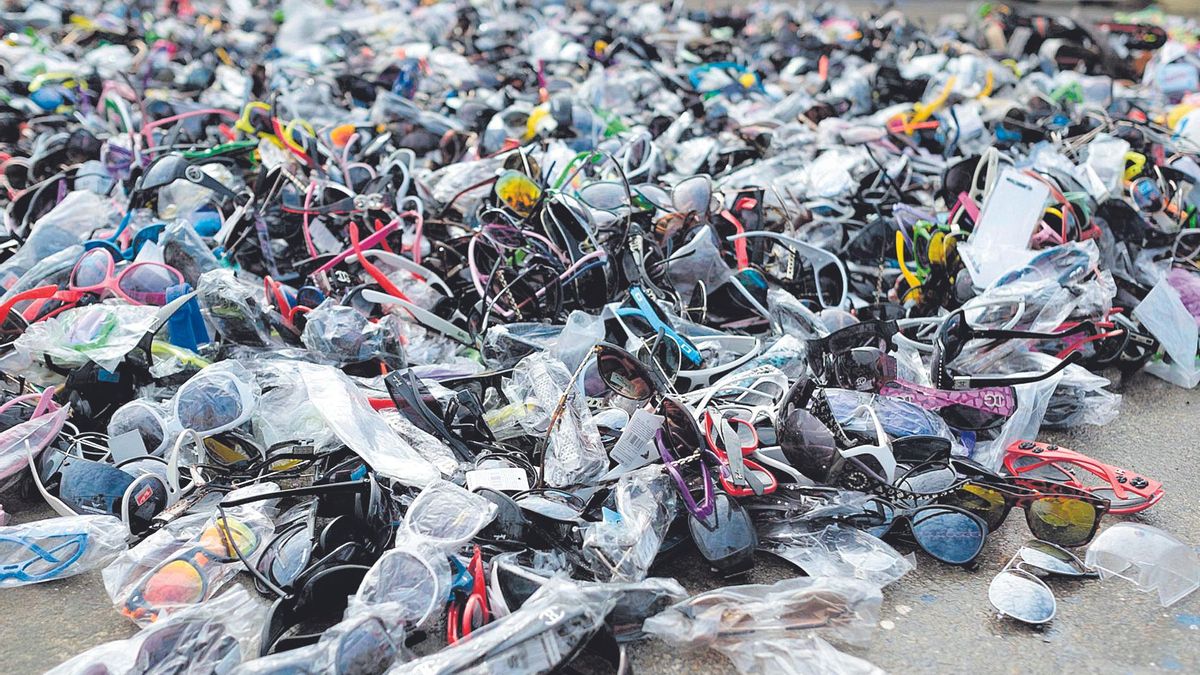 Cientos de gafas falsificadas apiladas en el suelo de un almacén.
