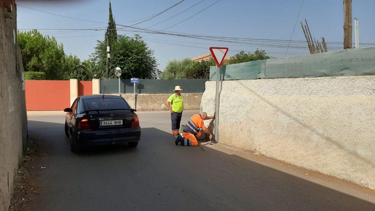 Unos operarios arreglan una señal de ceda el  paso tumbada por un gran camión en el cruce de Sedenyet dela Democràcia con Fornets.