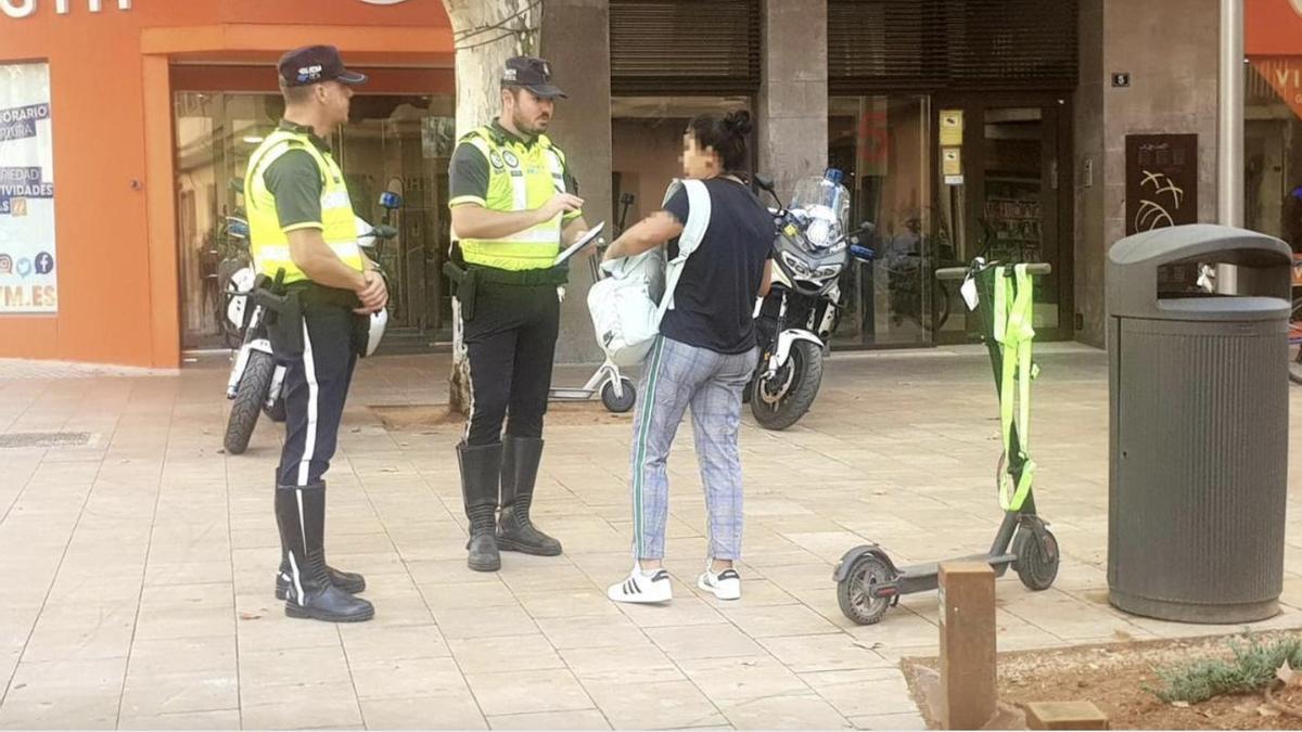 Agentes de la Policía Local piden documentación a una usuaria de un patinete eléctrico.