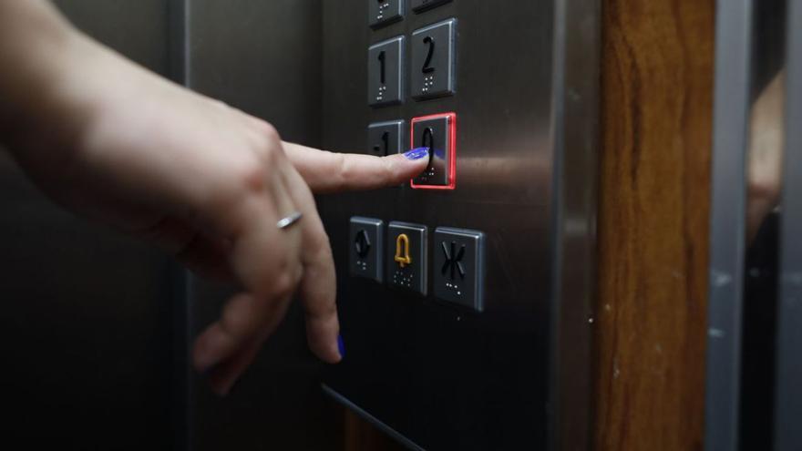 Una usuaria pulsa el bótón del ascensor para acceder a la planta baja. |   // MIGUEL ÁNGEL GRACIA