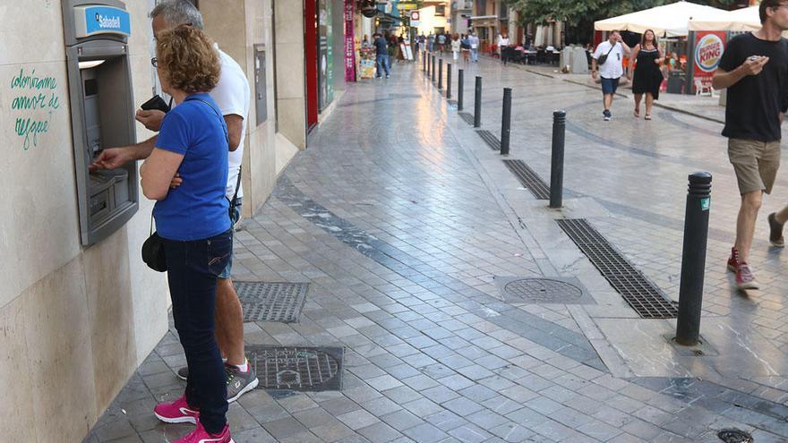 Clientes sacan dinero de un cajero automático.