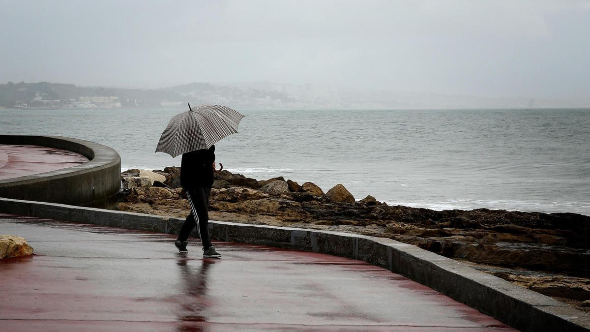 Archivo - Una persona con un paraguas bajo la lluvia en Lisboa, Portugal