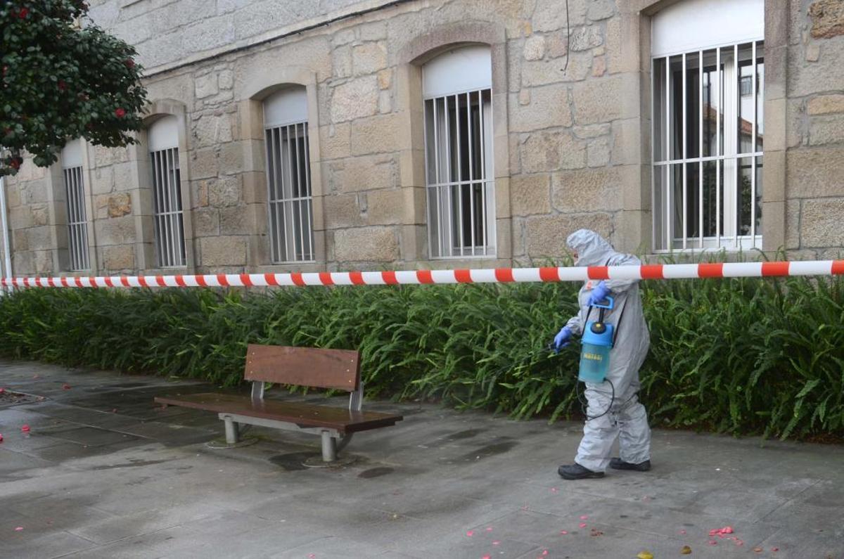 Un técnico desinfecta las inmediaciones de una residencia en Caldas donde hay un afectado. | NOE PARGA