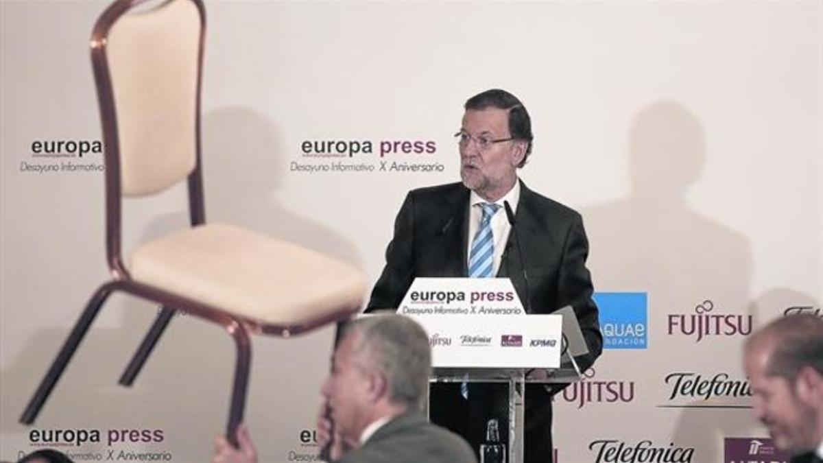 Un asistente mueve una silla durante la conferencia de Rajoy, ayer en Madrid.
