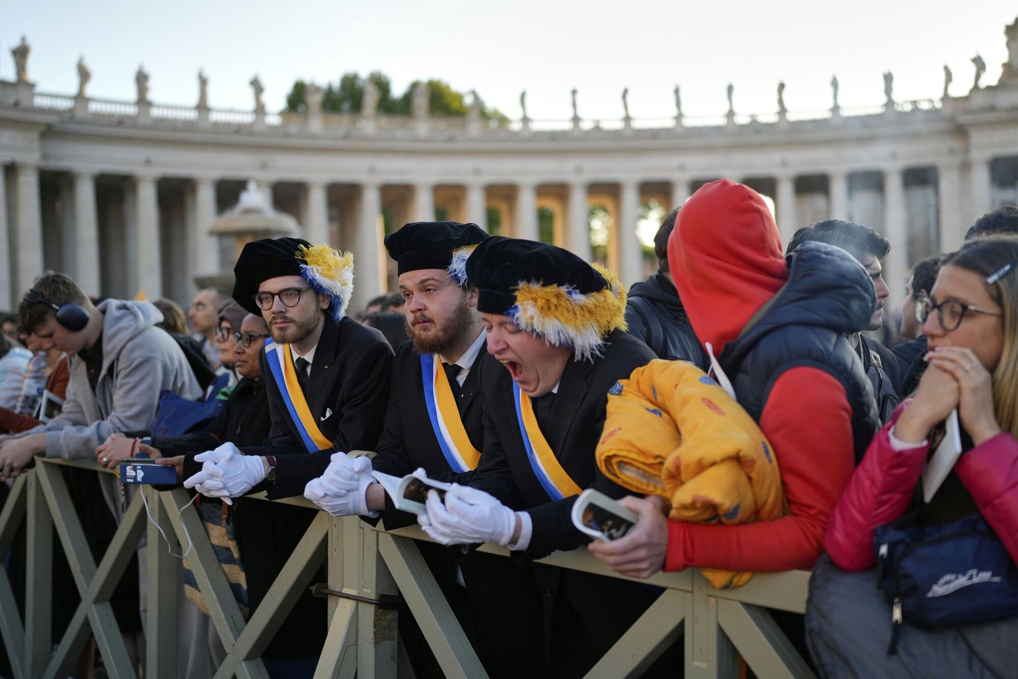 A man yawns as people arrive St. Peter's Square ahead of the funeral of Pope Francis at the Vatican, Saturday, April 26, 2025. (AP Photo/Andreea Alexandru)