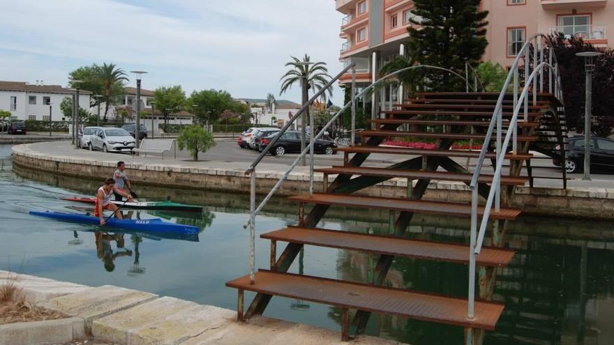 Dos piragüistas pasan bajo uno de los deteriorados puentes de los canales.