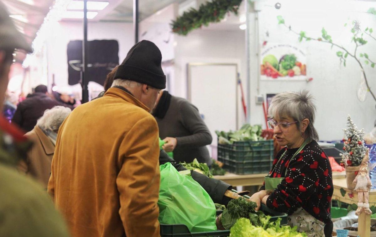 Varios personas en uno de los puestos del mercado zamorano. | ALBA PRIETO