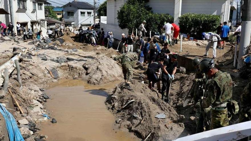 Militares y civiles buscan víctimas entre los escombros dejados por las lluvias torrenciales.