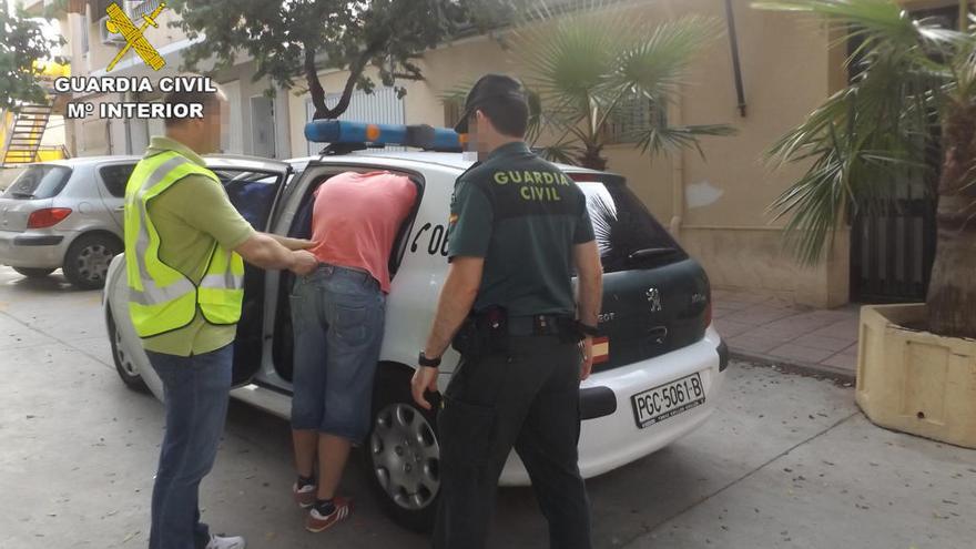 Agentes con uno de los detenidos