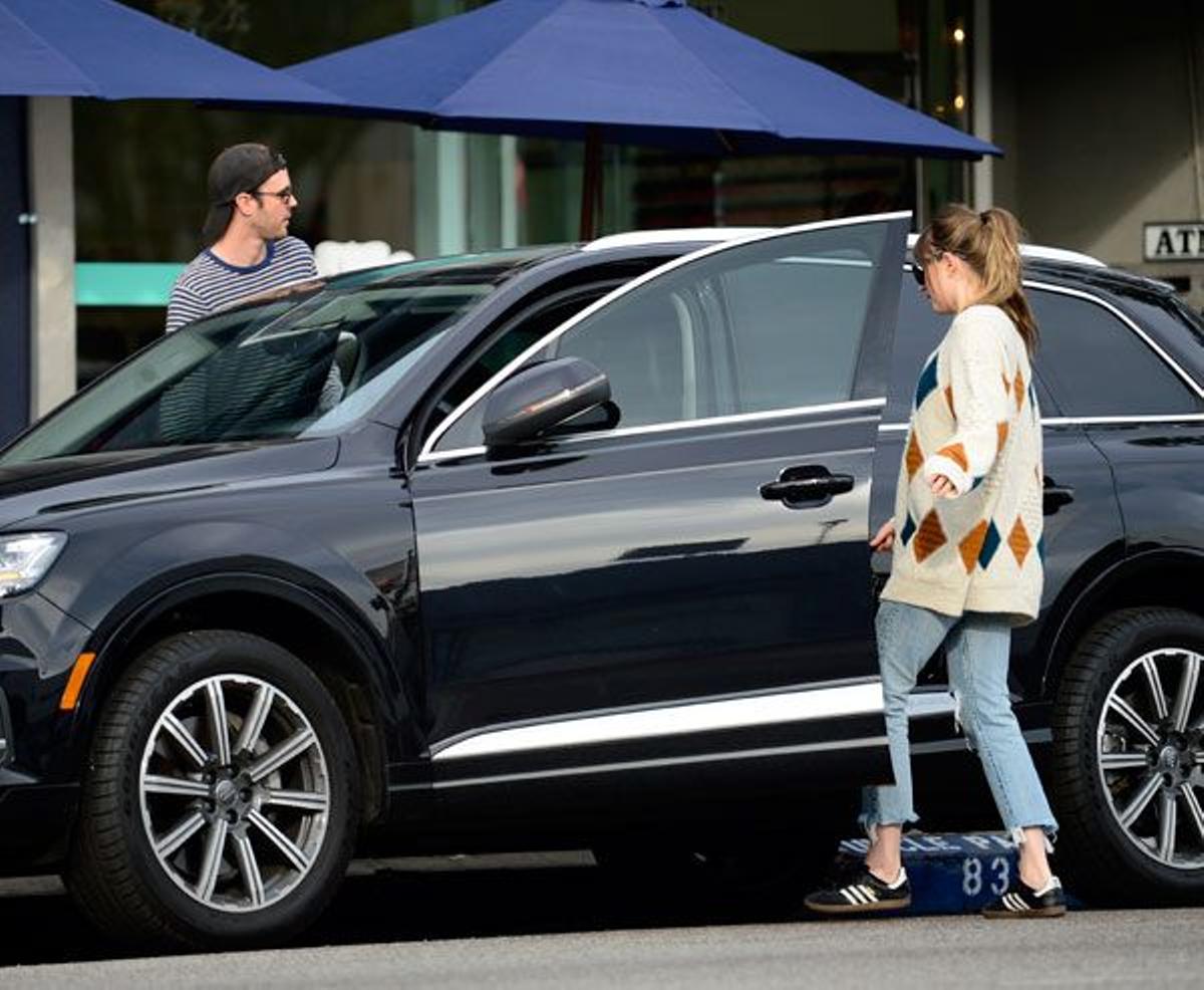 Dakota Johnson con pantalones vaqueros y zapatillas Adidas