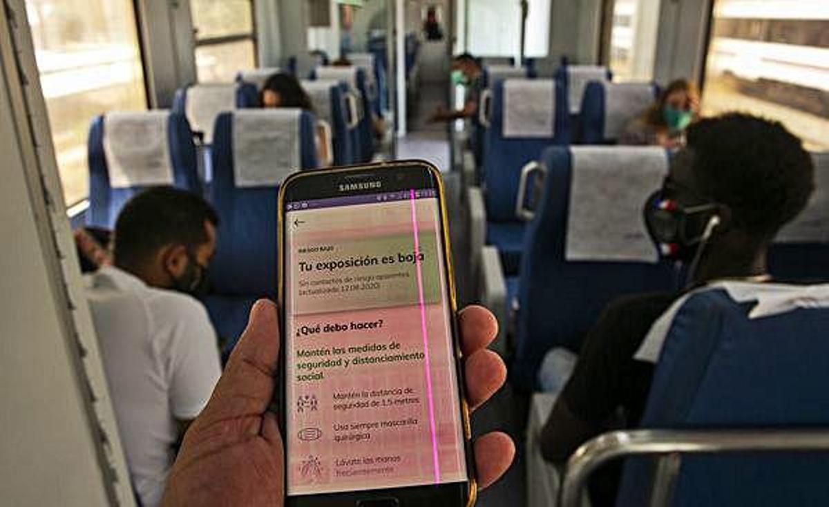 Un viajero consulta su app en el vagón de un tren.