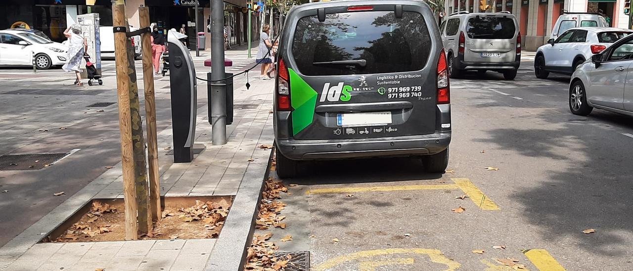 Un coche eléctrico recarga la batería en un punto situado en la Plaza Fleming de Palma.