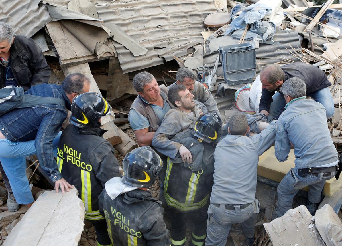 A man is carried away after having been rescued alive from the ruins following an earthquake in Amatrice, central Italy, August 24, 2016. REUTERS/Remo Casilli