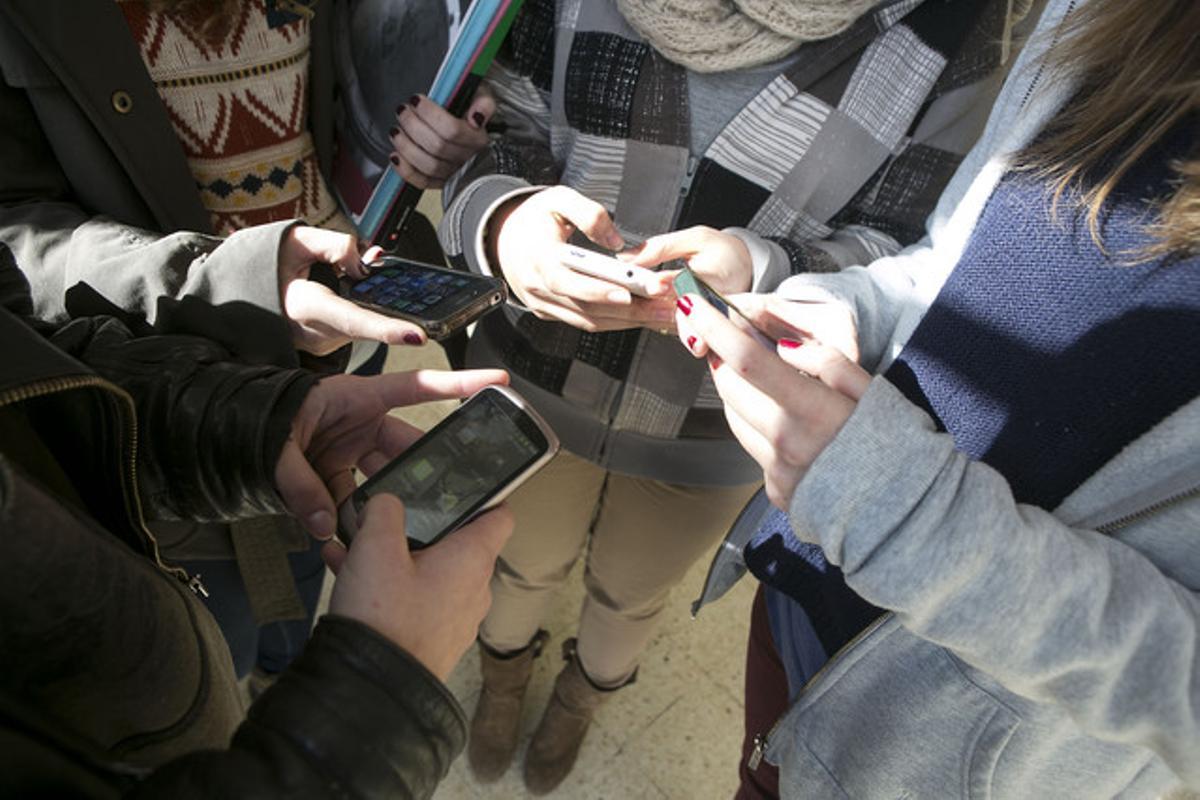 Un grup de menors, amb els seus telèfons mòbils a Barcelona. Un grup de menors, amb els seus telèfons mòbils a Barcelona.