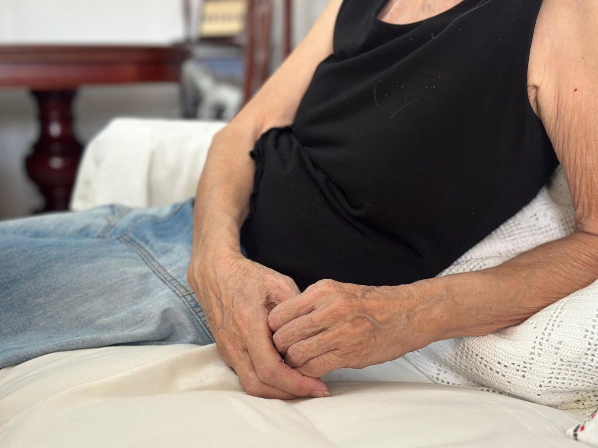 Torso de María Salud desde el sofá de su comedor.