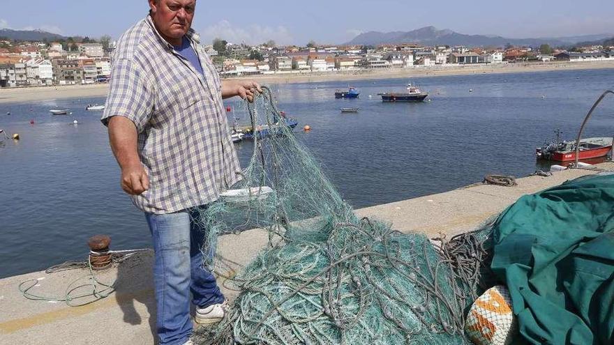 José Manuel González Juste mostraba ayer los trasmallos dañados en el muelle de Panxón. // Ricardo Grobas