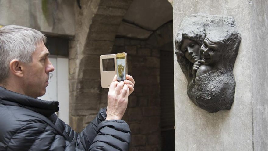 Una persona fa una foto a una escultura de Ramon Oms