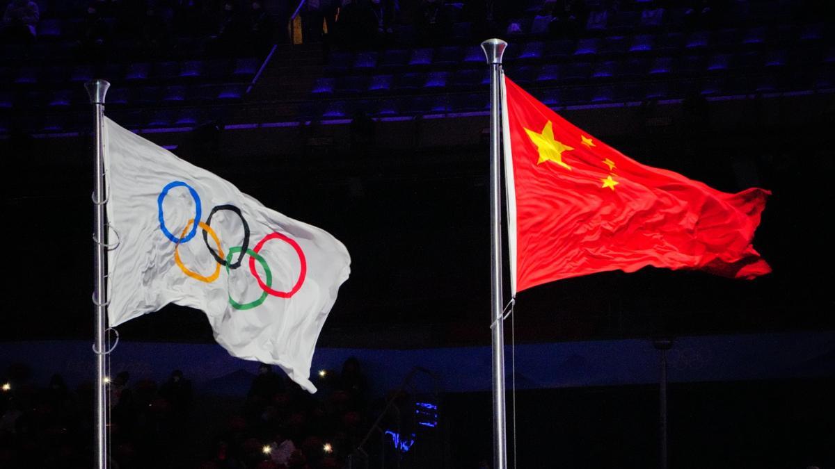 La bandera de China ondea junto a la olímpica.