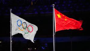 La bandera de China ondea junto a la olímpica.