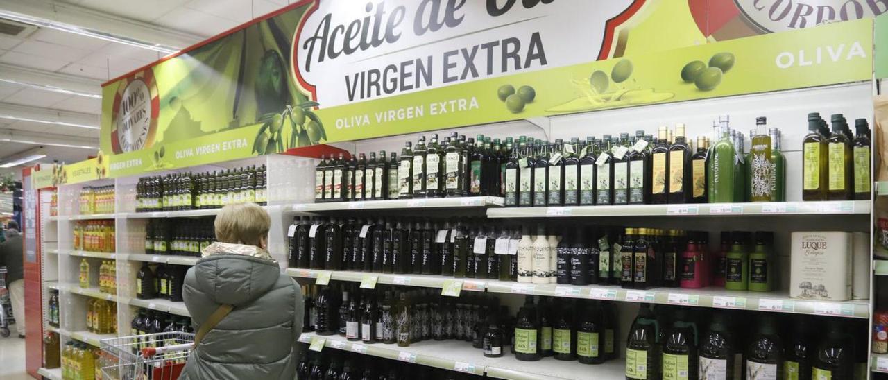 Una clienta observa los precios de varias marcas de aceite de oliva en un supermercado cordobés.