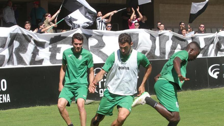 Varios jugadores entrenando con una pancarta de ánimo en las gradas