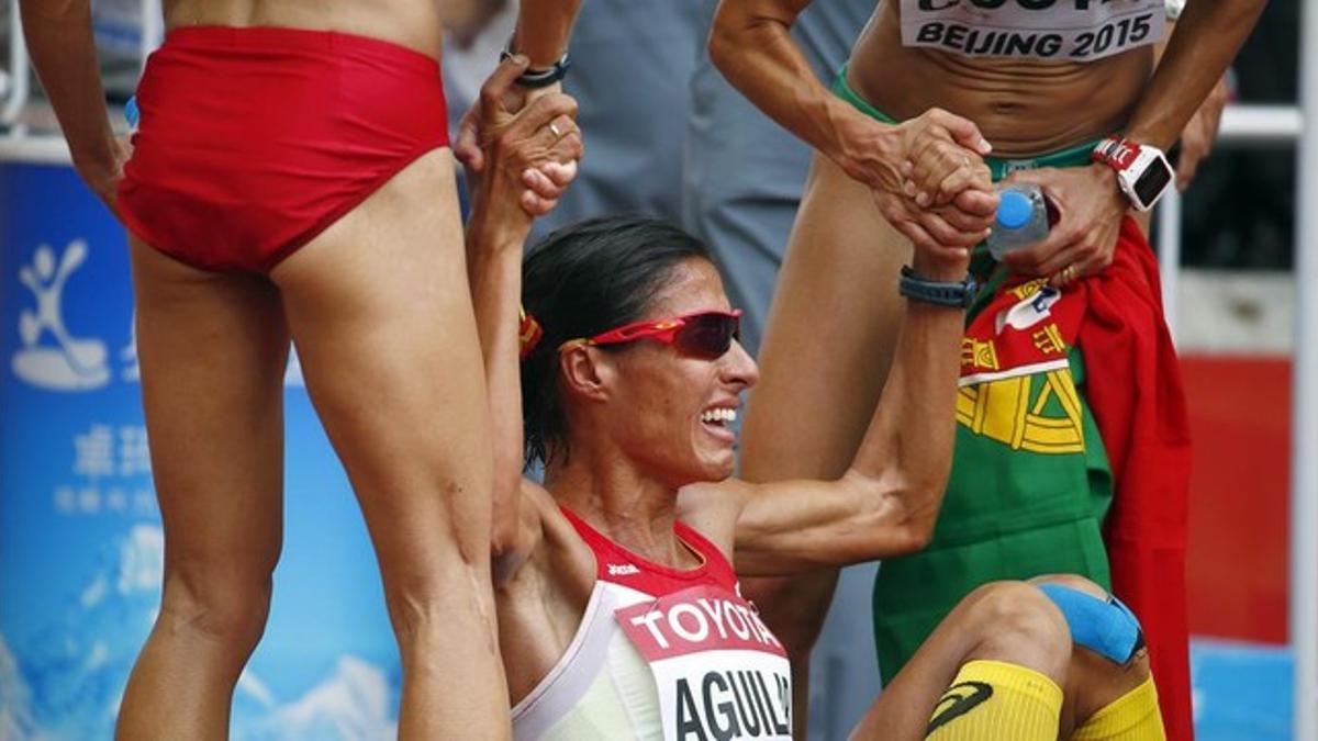 Aguilar es ayudada por otras atletas tras el maratón femenino.