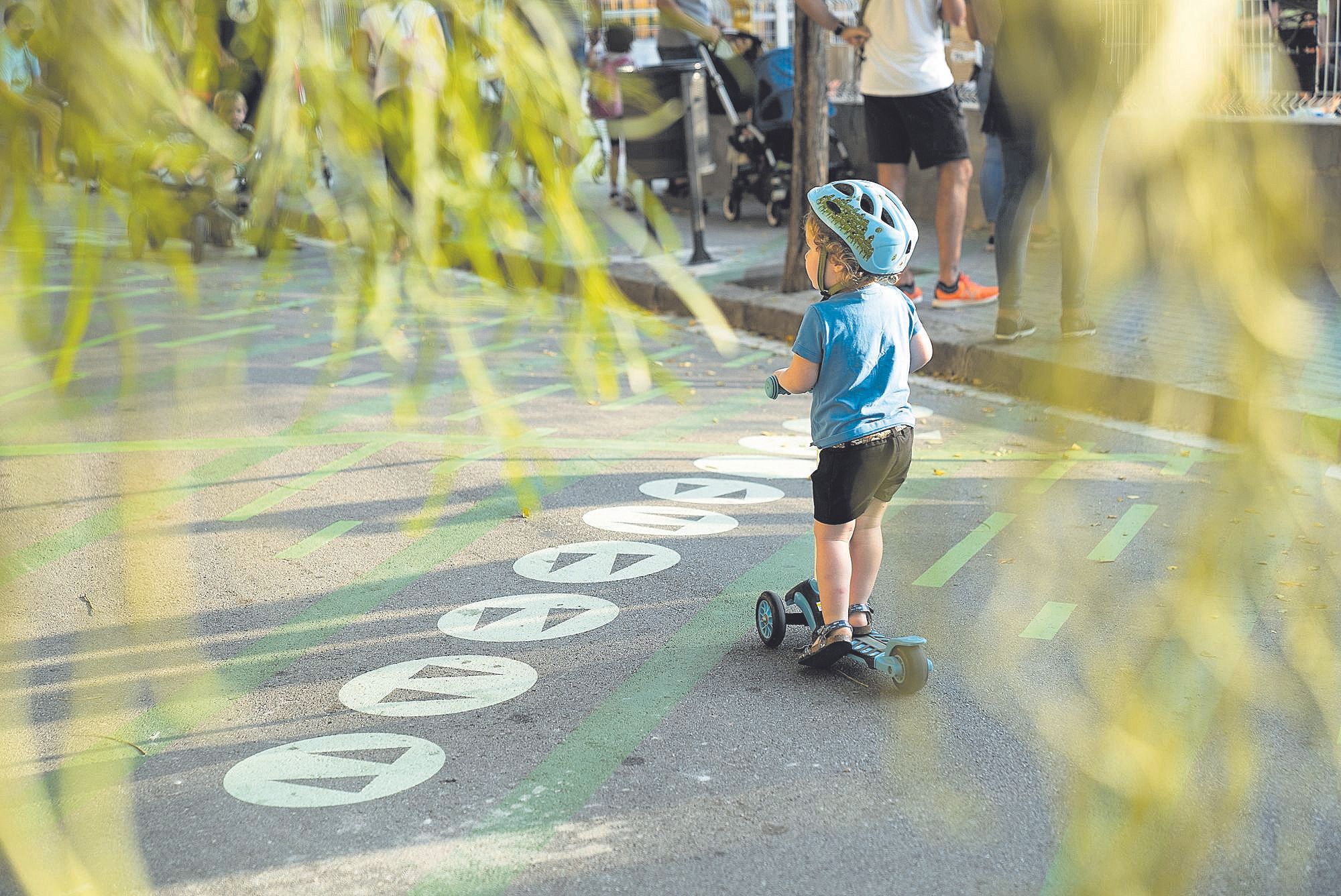 Niño jugando con el patinete en la zona pacificada