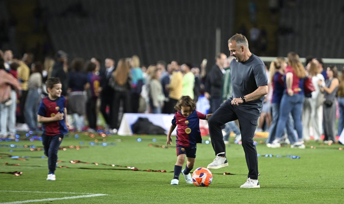 Barcelona. 18.05.2025. Deportes. Hansi Flick con el balón en los pies juega con dos niños al finalizar las celebraciones por el título de liga durante el partido de liga entre el FC Barcelona y el Villarreal en el estadio Lluis Companys. Fotografía de Jordi Cotrina