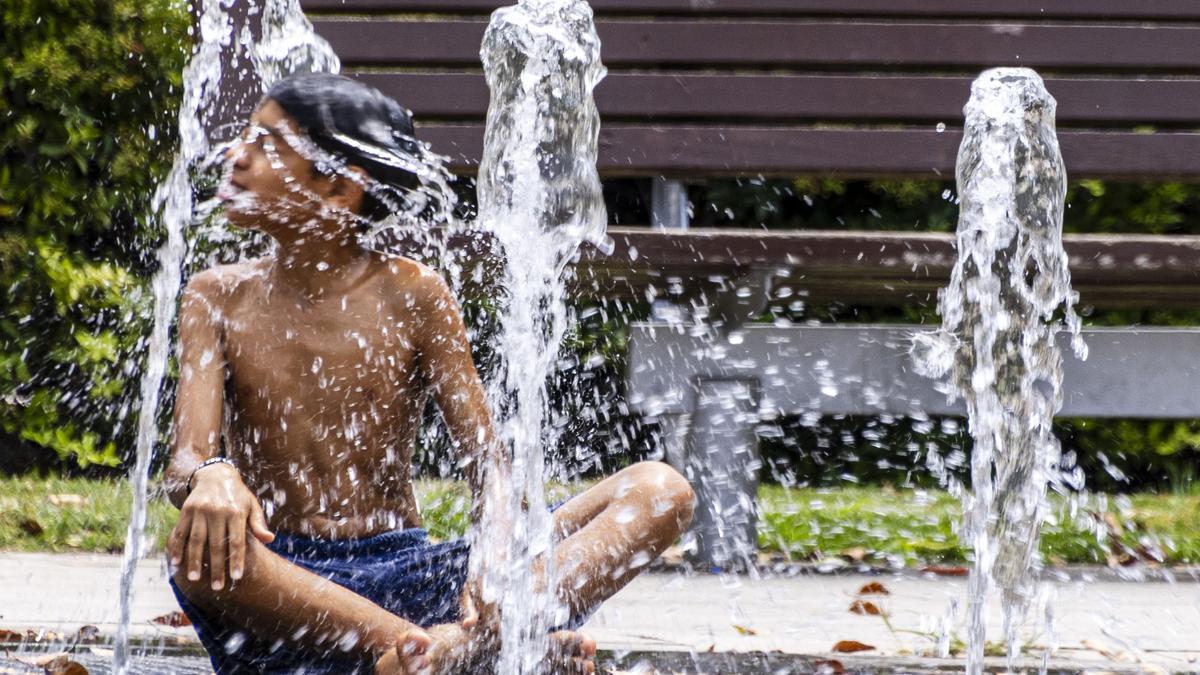 Ein Junge erfrischt sich am Montag (10.7.)an einem Springbrunnen im Parc de Ses Estacions in Palma.