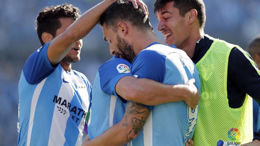 Los jugadores del Málaga CF se abrazan tras el gol de Borja Bastón.