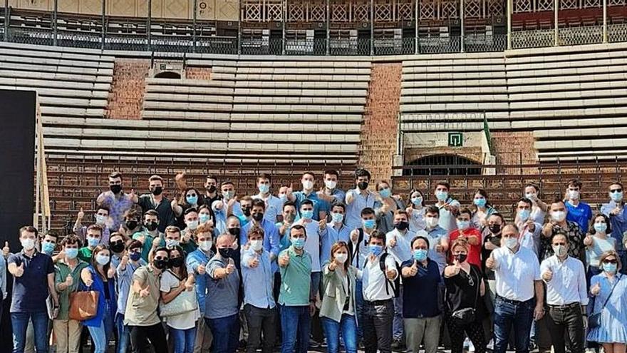 Mazón y voluntarios de Nuevas Generaciones del PP, ayer, en la plaza de toros de Valencia.