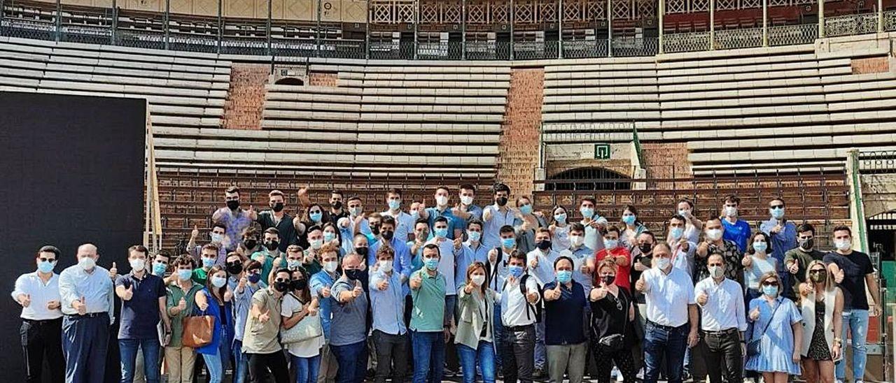 Mazón y voluntarios de Nuevas Generaciones del PP, ayer, en la plaza de toros de Valencia.