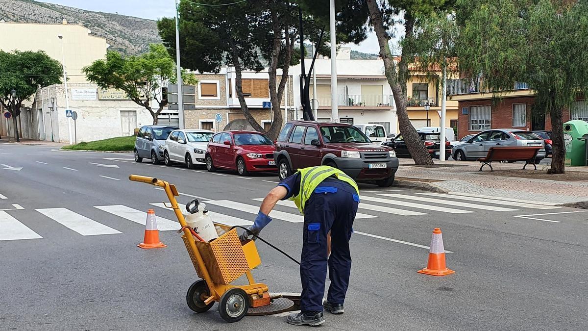 Un trabajador de empresa de control de plagas actúa en una alcantarilla.