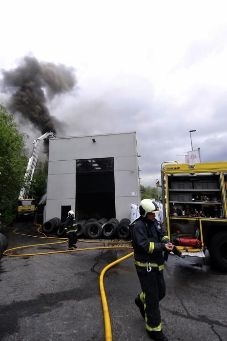 Los bomberos sofocan un incendio en una empresa de neumáticos del polígono langreano de La Moral