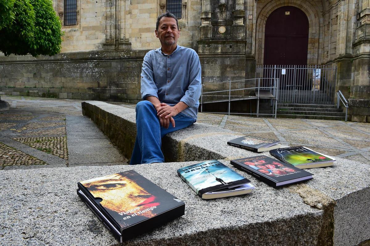 Julio Pérez, con todas las novelas que ha publicado, ante la Catedral de Plasencia.