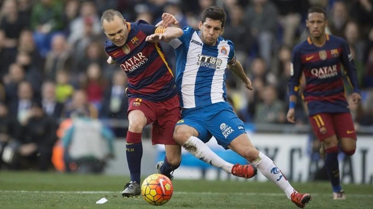 Iniesta y Javi López disputan un balón.