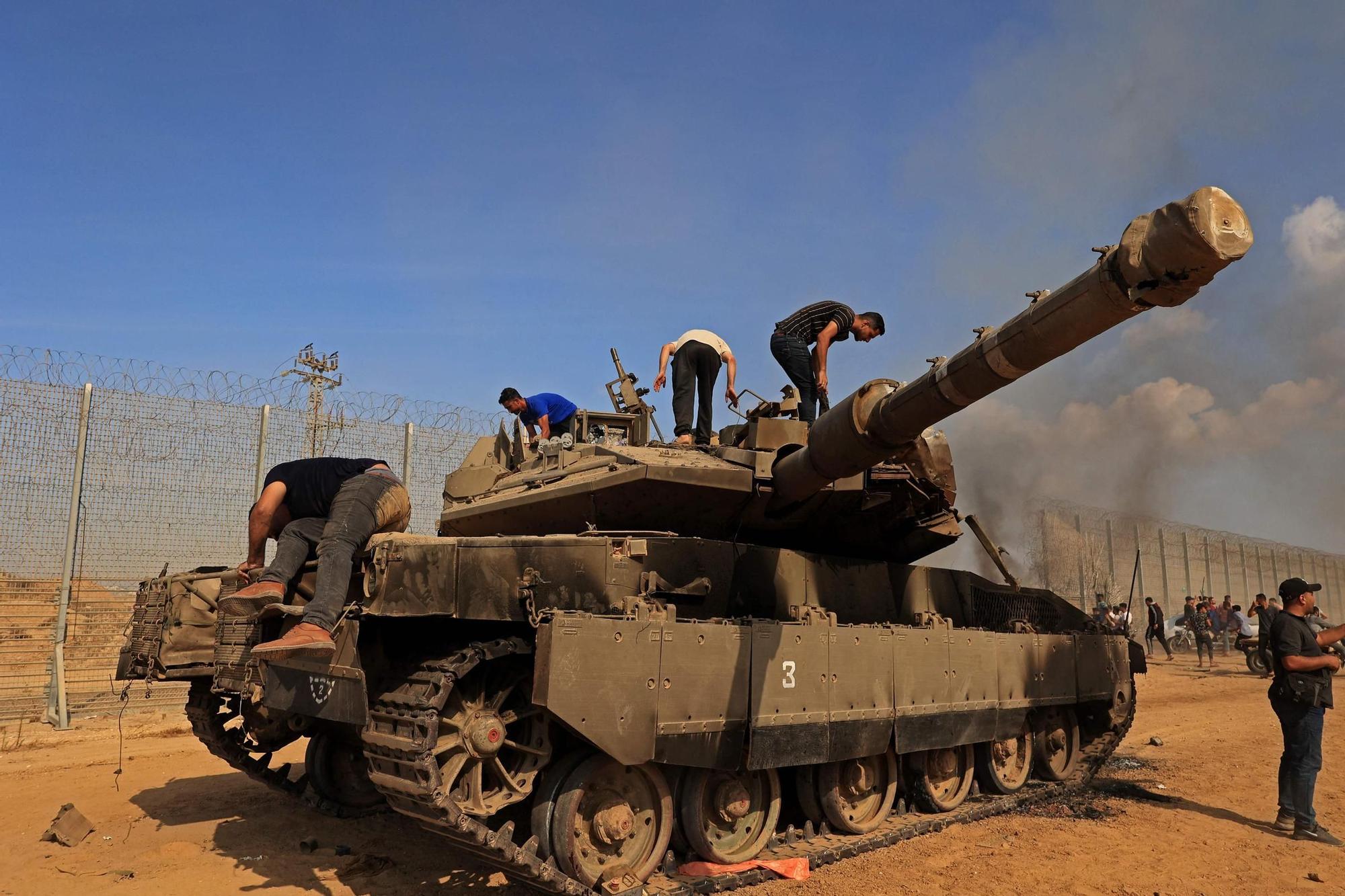 Ciudadanos palestinos se apoderan de un tanque israelí tras cruzar la valla fronteriza con Israel desde Khan Yunis en la parte suroeste de la Franja de Gaza.