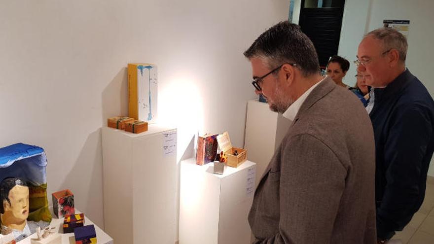 La exposición de las cajas en la Casa de la Cultura con el edil de Cultura y detrás Domingo Cordero.