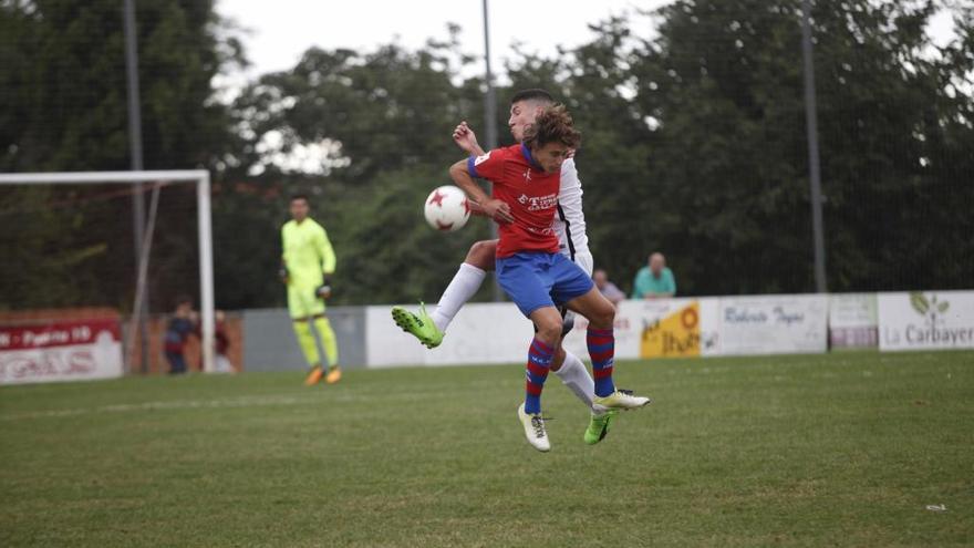 Expósito, de blanco, salta con un jugador del Ceares en el partido de Copa Federación de este verano.