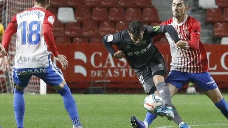 Borja López intenta robar un balón al jugador del Numancia Curro, con Javi Fuego de espaldas.