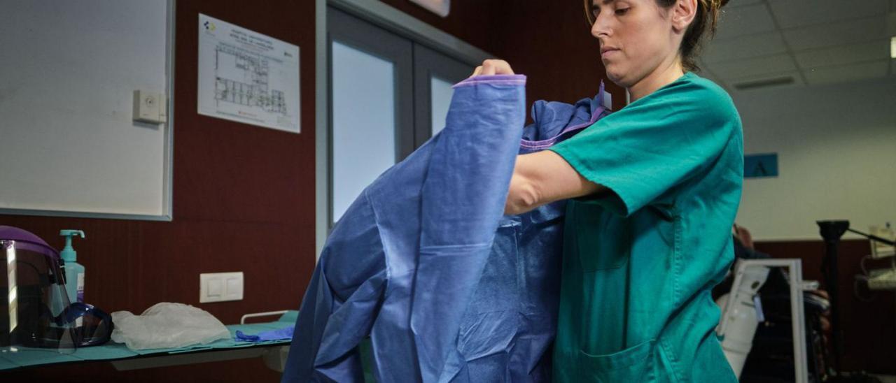 Una sanitaria se prepara para atender a un paciente en el área destinada a los pacientes covid.