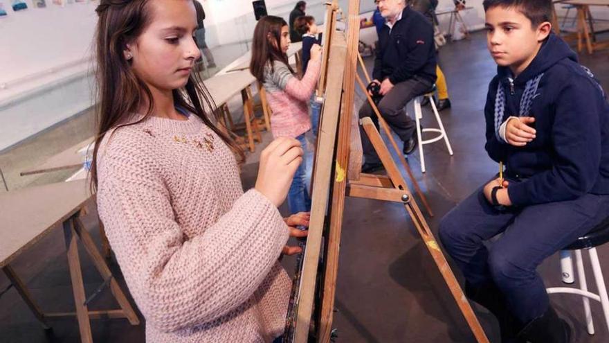 Niños pintando en la antigua Pescadería; a la derecha, un taller en la Factoría Cultural.