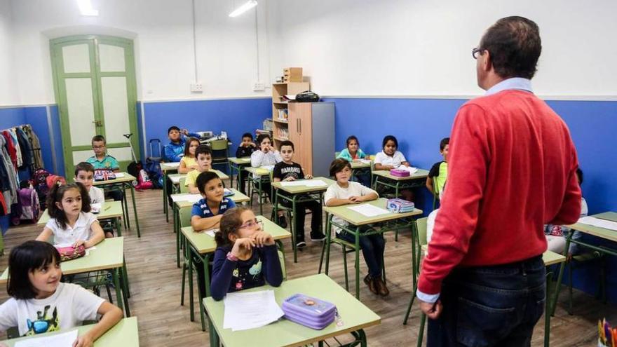 Un profesor y sus alumnos, ayer, en un aula renovada del colegio Dolores Medio.